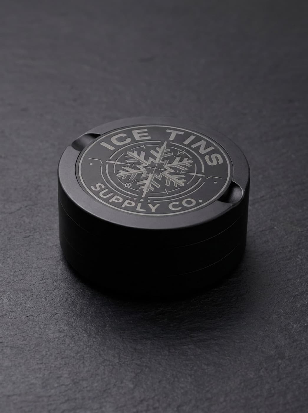 The engraved Ice Tins Supply Co. lid seen from above on dark slate